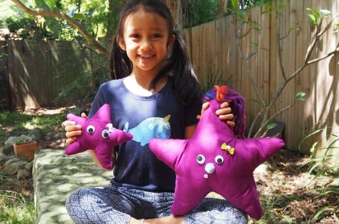 Child showing the star softie she has sewn